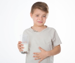 child with painful expression after drinking milk