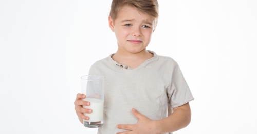 child with painful expression after drinking milk